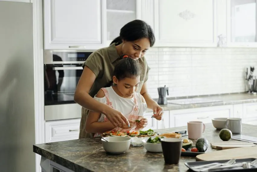 A parent and child cooking together