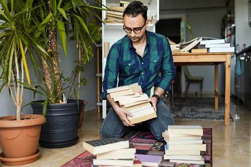 Man with Books Decluttering Cleaning the work from home space