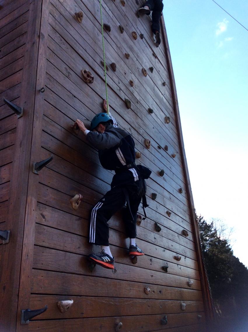 Probably a man climbing a rock face