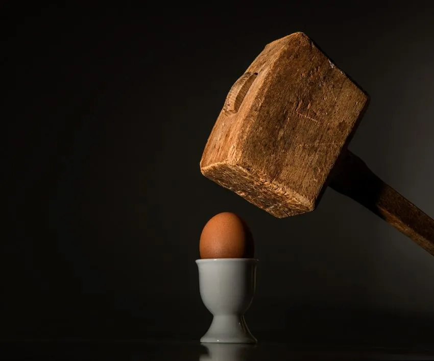 A hammer cracking an egg