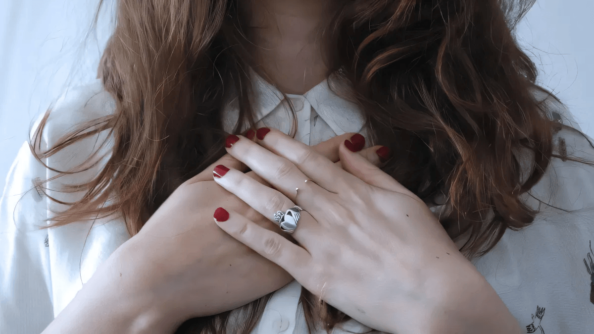 woman holding her hands over her heart