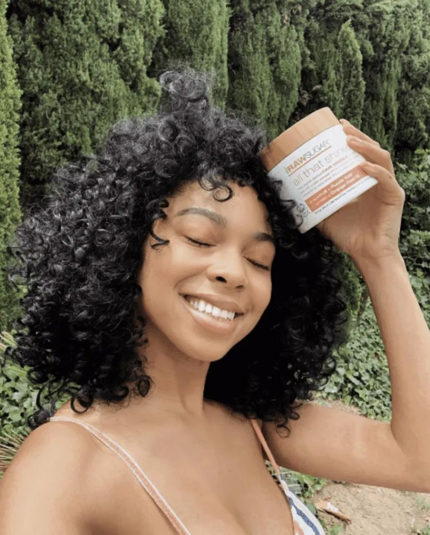The Absolute Best Hair Masks For Thirsty Curls: Trust Me Your Curls Will Thank You curly hair women holding hair mask