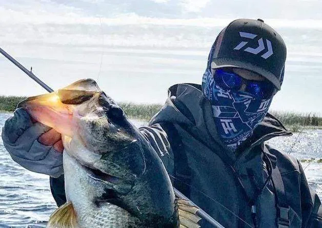 Fisherman with gaiter holding a caught fish