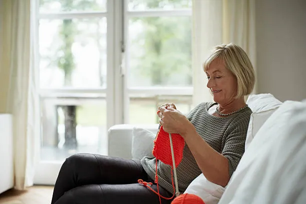 woman enjoying her knitting project woman enjoying her knitting project
