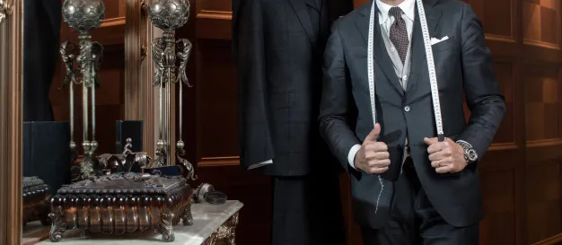 Man in a suit in a tailor shop Sharp dressed man in a suit with tailor equipment