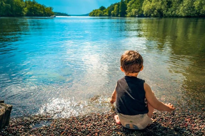 A child sitting by the lake