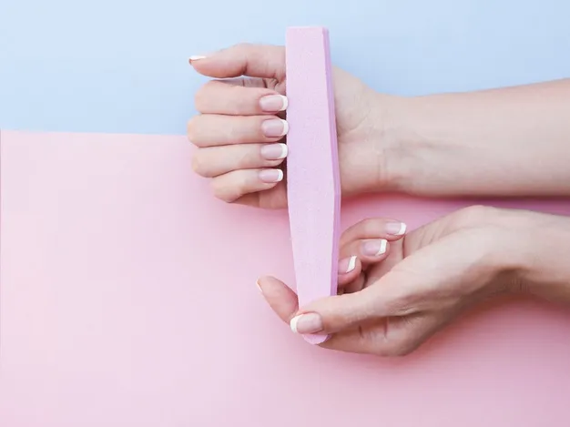 woman using a nail file for own manicure 