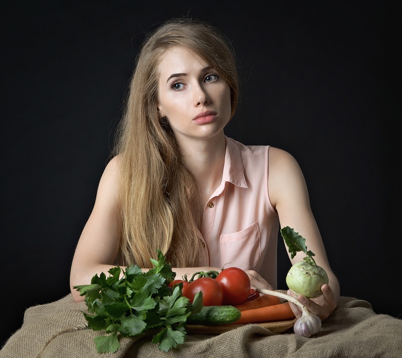 Sad Woman With Veg A woman looking morose over some vegetables