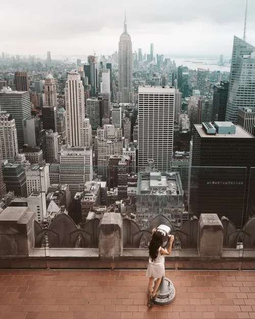 woman looking through tower viewer tourist enjoying the site of a city