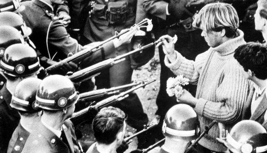 Protestors put flowers in National Guard rifles
