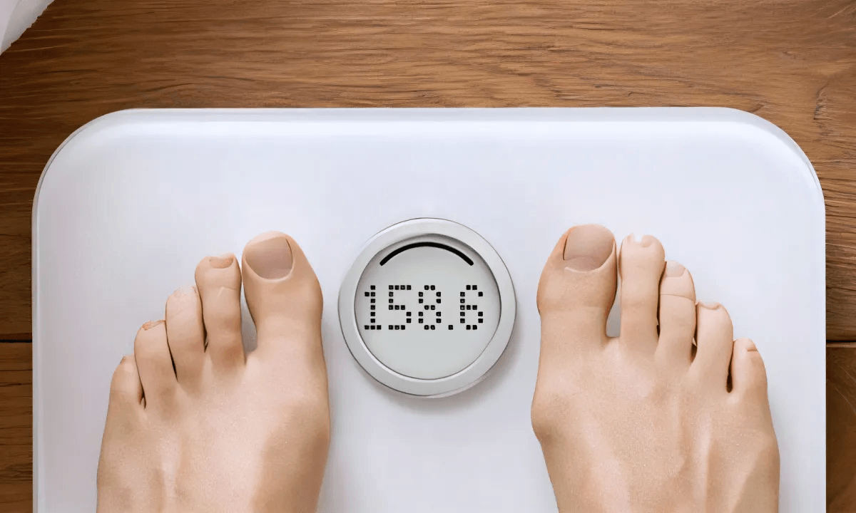 women on weight scale image