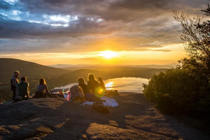 A group of people hanging out as the sunsets foster a community