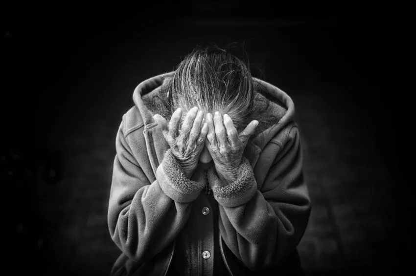 Mujer mayor de luto Old woman with head in hands grieving