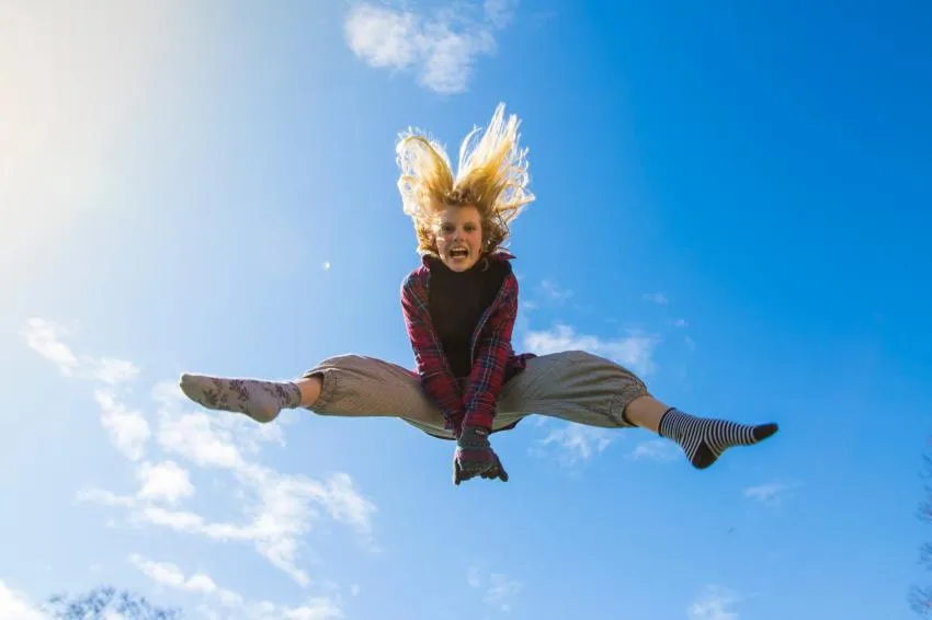 A person with long hair jumping high