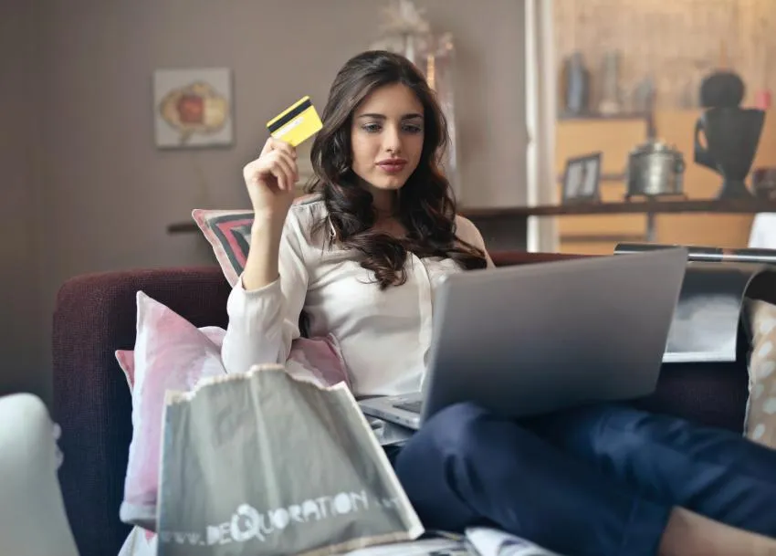 woman comfortably shopping online sitting on her couch