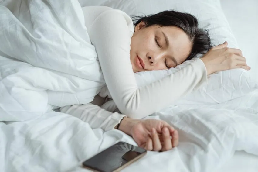 A person sleeping next to a phone
