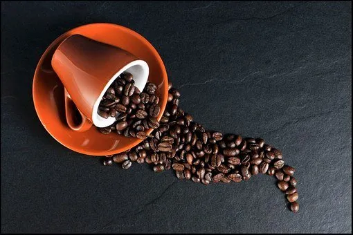 Coffee beans spilling from a cup