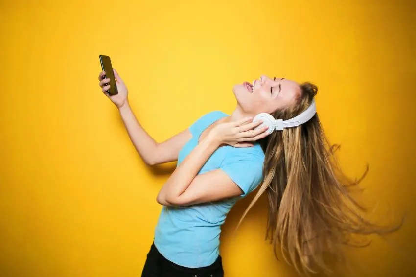 Woman singing and dancing with headphones on