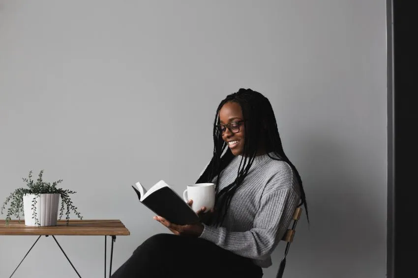 woman reading book woman reading book with mug in hand