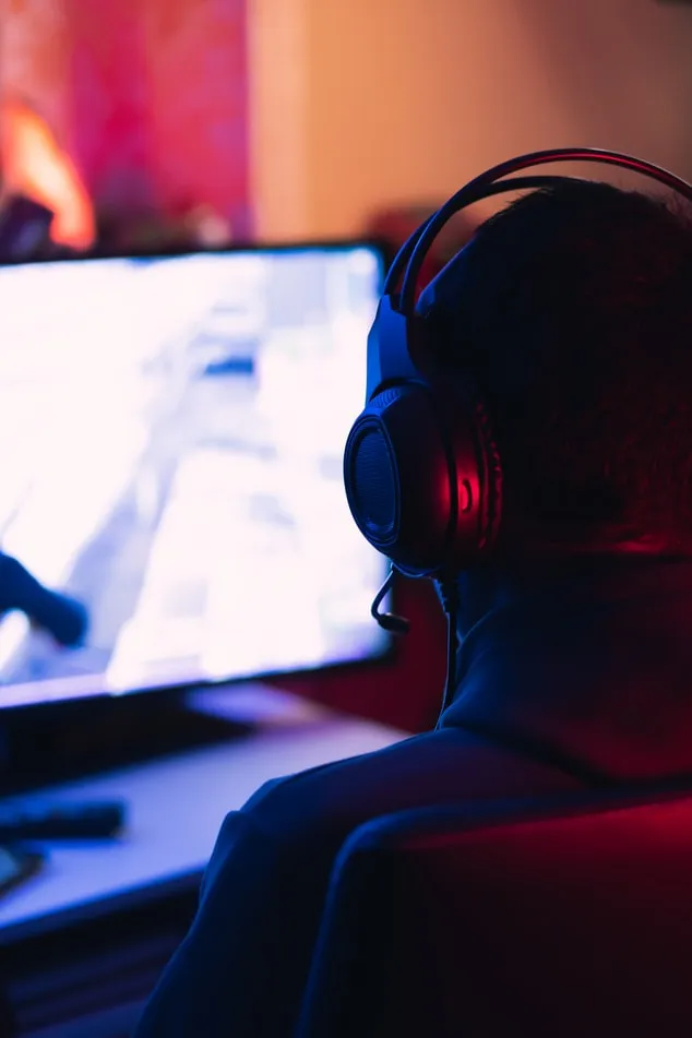 Man sitting at desk with monitor playing game