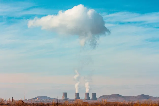 Planta nuclear en zona de terreno abierto Nuclear power plant with blue sky and mountains